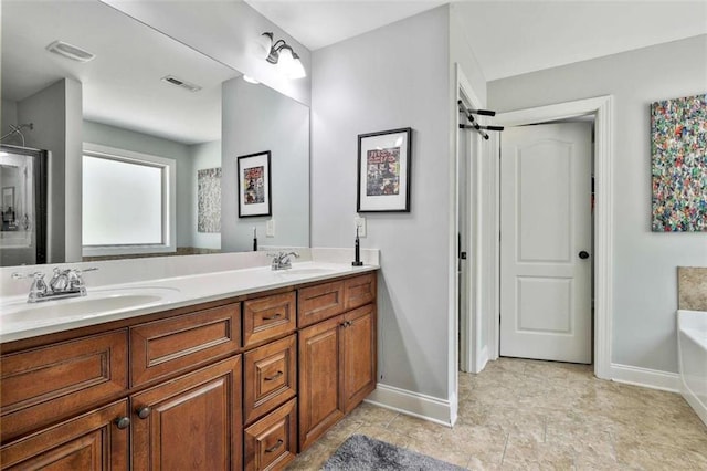 bathroom featuring visible vents, baseboards, a sink, and a bathtub