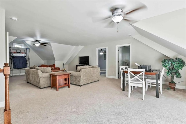 living area with baseboards, lofted ceiling, a ceiling fan, and light colored carpet