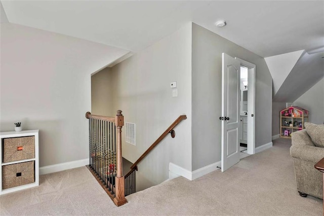 interior space featuring carpet floors, an upstairs landing, visible vents, and baseboards