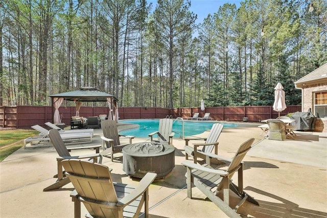 view of swimming pool with a fenced in pool, a fenced backyard, grilling area, a fire pit, and a gazebo