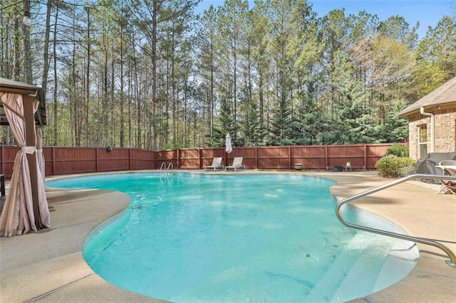 view of swimming pool featuring a fenced in pool, a patio, and a fenced backyard
