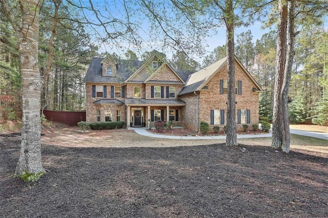 craftsman inspired home featuring brick siding and a porch