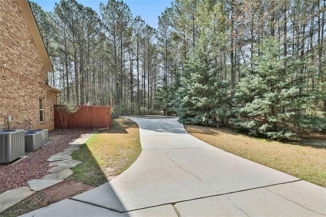 view of home's community featuring a yard, driveway, and fence