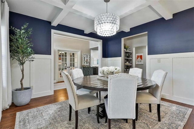 dining room featuring wood finished floors, a decorative wall, and wainscoting