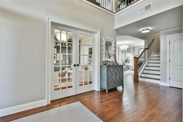 entryway with stairway, wood-type flooring, french doors, and visible vents