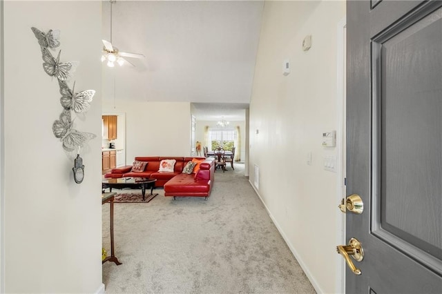 interior space featuring ceiling fan with notable chandelier and a high ceiling