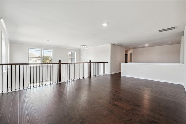 spare room featuring crown molding, wood finished floors, and visible vents