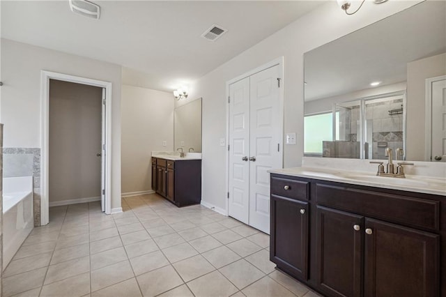 bathroom with visible vents, tile patterned floors, two vanities, a shower stall, and a sink