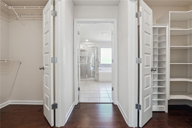 walk in closet with wood finished floors