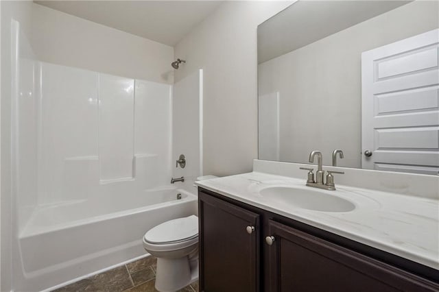 bathroom featuring vanity, shower / bath combination, stone finish floor, and toilet
