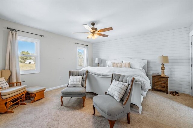 bedroom with light colored carpet, baseboards, ceiling fan, and multiple windows