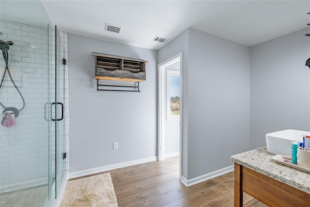 bathroom featuring visible vents, wood finished floors, and a stall shower