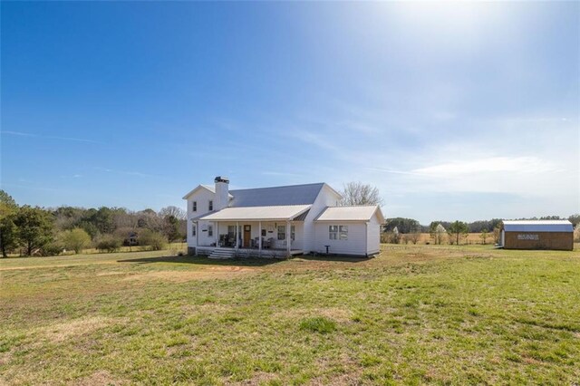 view of front of property with a front lawn, a porch, and a chimney