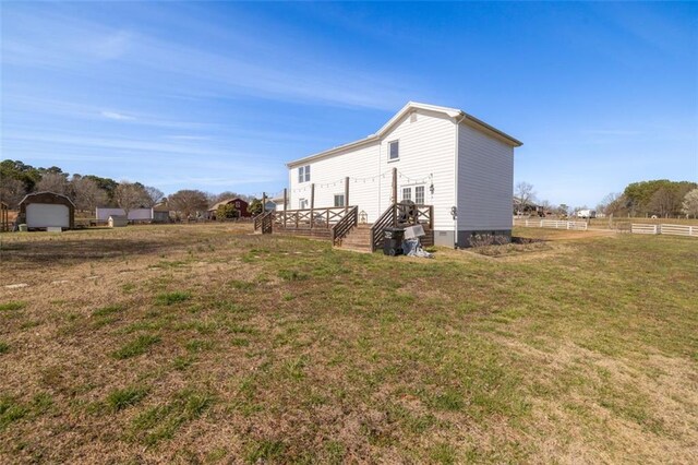 view of side of property with crawl space, a lawn, a deck, and fence