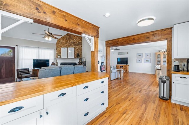 kitchen featuring wood counters, open floor plan, a fireplace, and light wood-style flooring