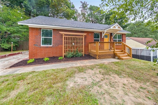 view of front facade with a wooden deck and a front lawn