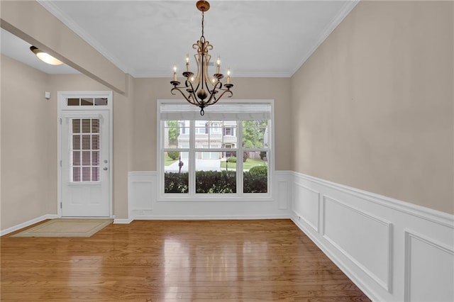5040 Stonehaven Vw, Cumming, GA 30040 - unfurnished dining area featuring a chandelier, wood finished floors, a wainscoted wall, and ornamental molding