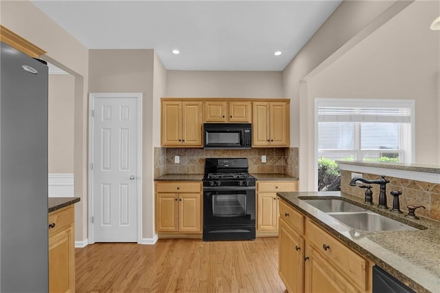 5040 Stonehaven Vw, Cumming, GA 30040 - kitchen featuring black appliances, a sink, light wood-type flooring, backsplash, and dark stone counters