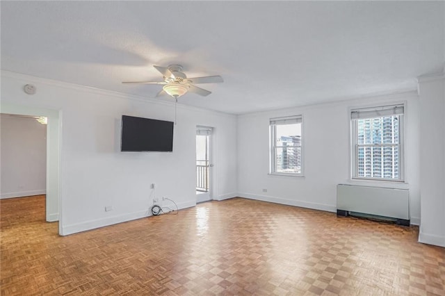 empty room featuring radiator heating unit, ceiling fan, crown molding, and light parquet floors