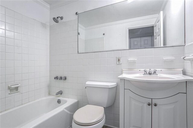 full bathroom with toilet, tile walls, tiled shower / bath, vanity, and crown molding