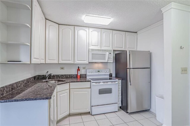 kitchen with white cabinetry, sink, a textured ceiling, light tile patterned floors, and white appliances