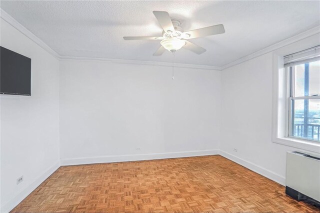 empty room with ornamental molding, ceiling fan, a textured ceiling, light parquet flooring, and radiator heating unit