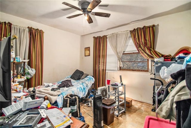 bedroom with a ceiling fan, baseboards, and wood finished floors