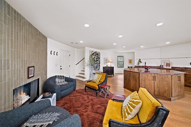 595 Overbrook Dr NW, Atlanta, GA 30318 - living area featuring light wood-style floors, stairs, recessed lighting, tile walls, and a tiled fireplace