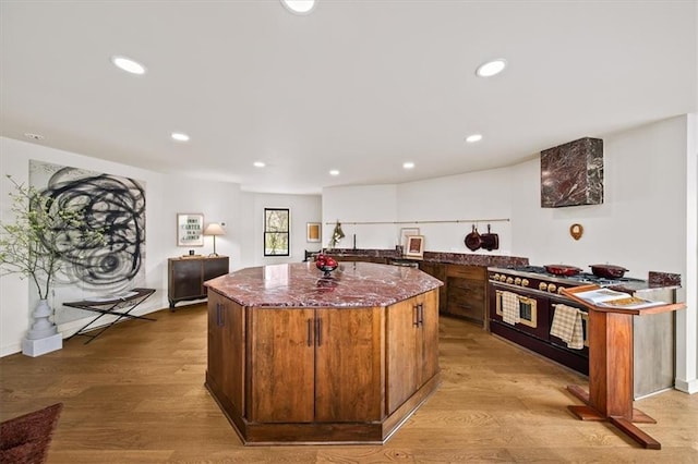 595 Overbrook Dr NW, Atlanta, GA 30318 - kitchen with double oven range, a kitchen island, dark stone counters, light wood-style flooring, and recessed lighting