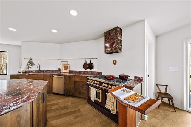 595 Overbrook Dr NW, Atlanta, GA 30318 - kitchen featuring stainless steel dishwasher, range with two ovens, dark stone counters, light wood-style floors, and a sink