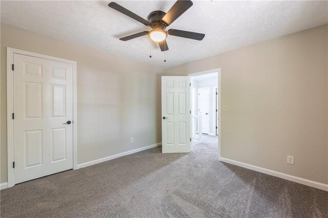 unfurnished bedroom with a textured ceiling, carpet, a ceiling fan, and baseboards