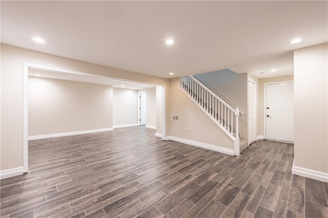 finished below grade area with stairs, baseboards, dark wood finished floors, and recessed lighting