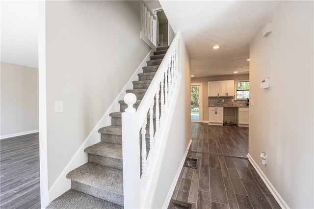 staircase with recessed lighting, baseboards, and wood finished floors