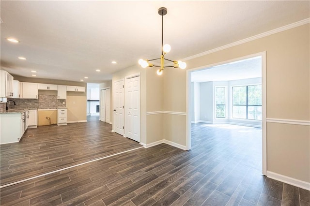 kitchen featuring white cabinets, dark wood finished floors, decorative backsplash, and a sink