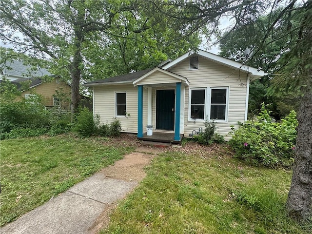 bungalow-style home with a front yard