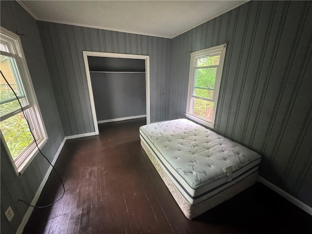bedroom with baseboards, dark wood-style floors, and a closet