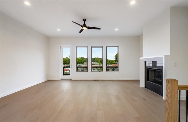 unfurnished living room featuring light wood-type flooring and ceiling fan