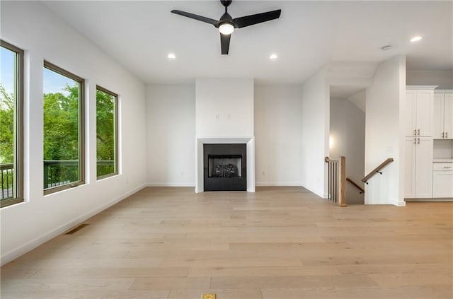 unfurnished living room featuring ceiling fan and light hardwood / wood-style floors