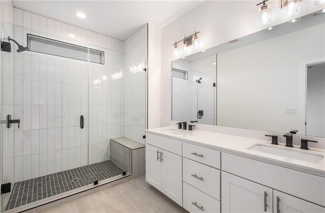 bathroom with tile patterned floors, vanity, and an enclosed shower