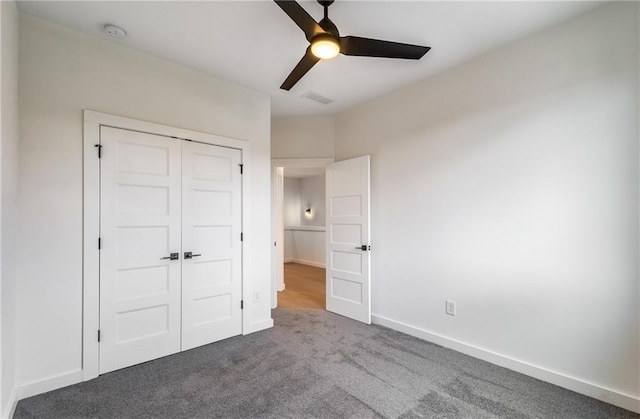 unfurnished bedroom featuring ceiling fan, a closet, and carpet