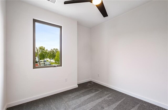 unfurnished room featuring dark colored carpet and ceiling fan