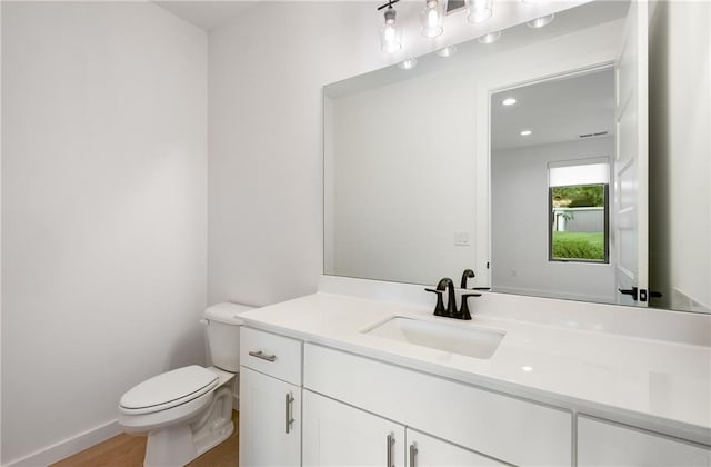 bathroom featuring hardwood / wood-style floors, vanity, and toilet