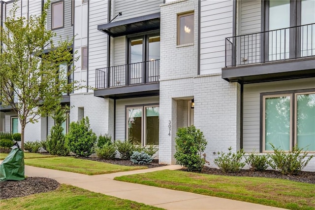 property entrance with a yard and a balcony