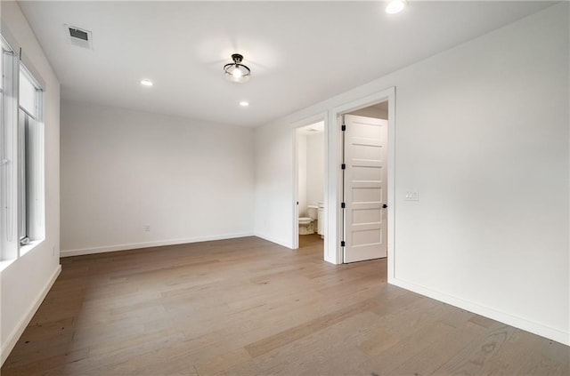 unfurnished bedroom featuring multiple windows and light wood-type flooring