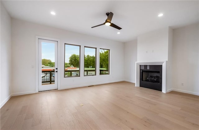 unfurnished living room featuring ceiling fan and light hardwood / wood-style flooring