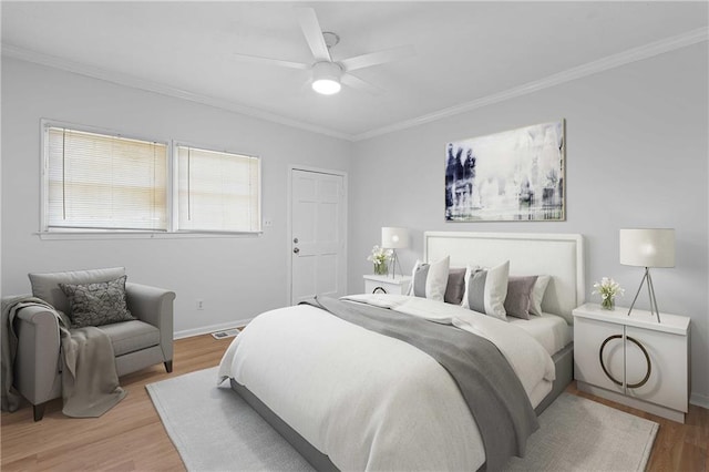 bedroom with ceiling fan, ornamental molding, and light wood-type flooring