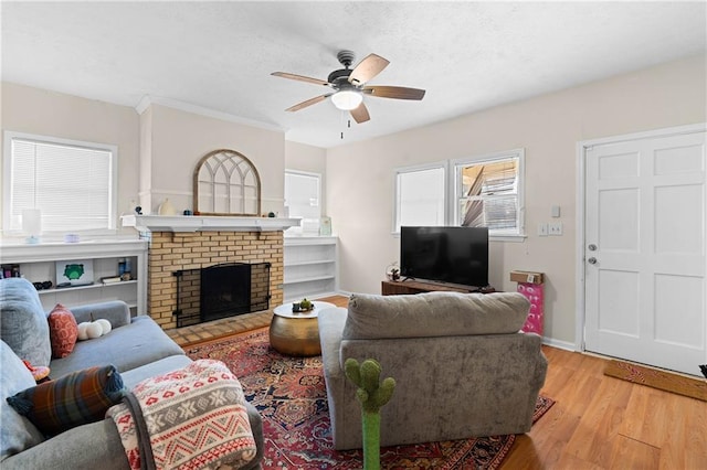 living room featuring a fireplace, ceiling fan, and light wood-type flooring