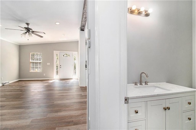 bathroom featuring vanity, vaulted ceiling, ceiling fan, crown molding, and hardwood / wood-style floors