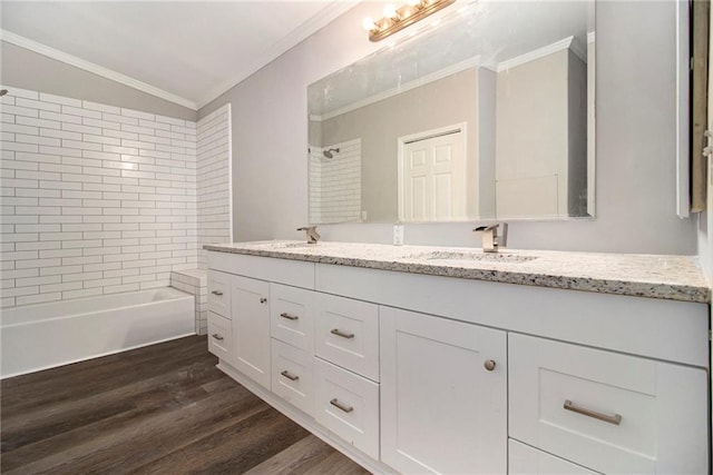 bathroom featuring ornamental molding, vanity, wood-type flooring, tiled shower / bath, and lofted ceiling