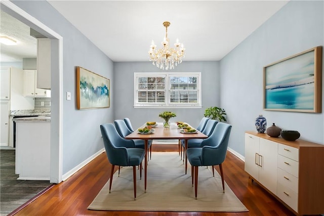 dining room featuring a notable chandelier, dark wood-style floors, and baseboards